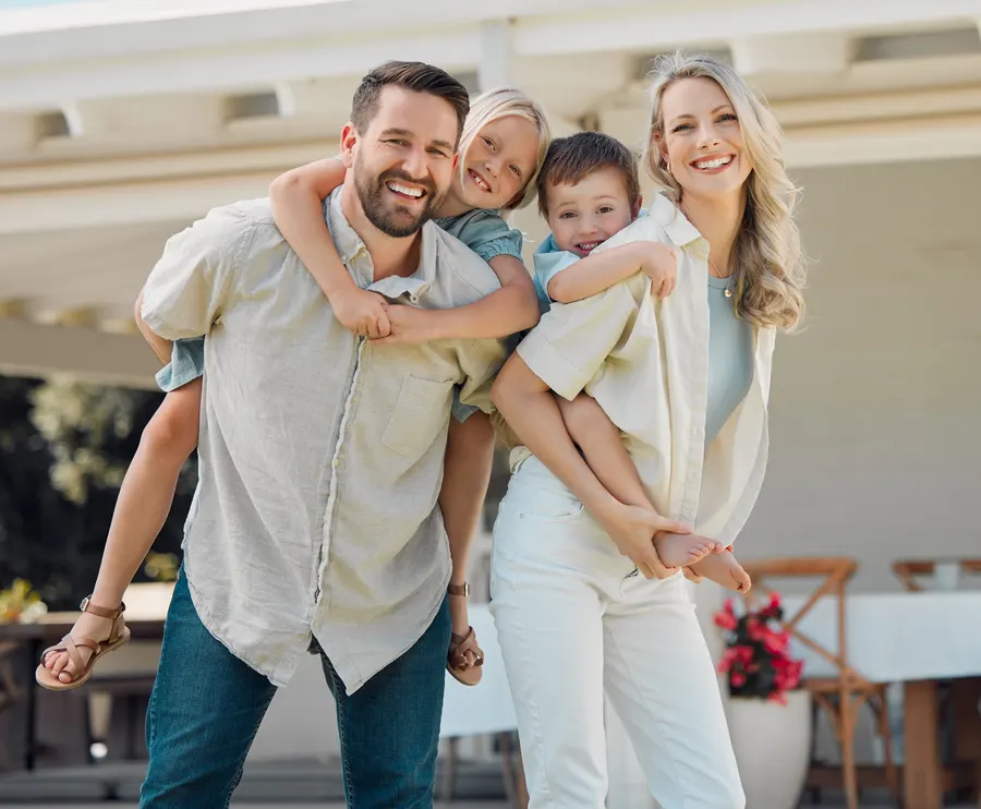 Smiling family of four outside their home
