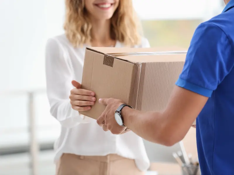 Courier handing a parcel to a woman