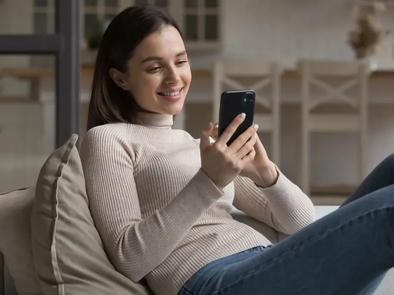 Woman reading a message on her phone at home